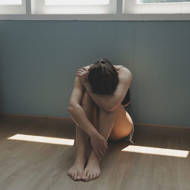 Person sitting alone in a quiet room, representing depression, isolation, and emotional support