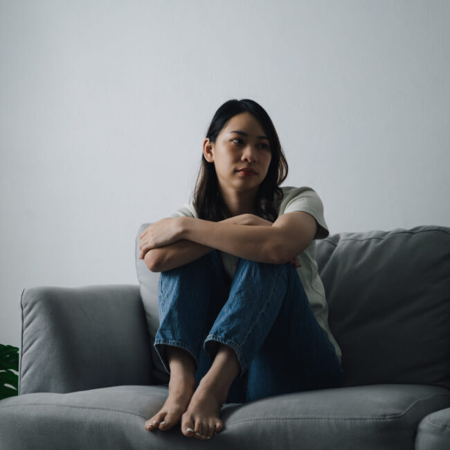 Woman sitting on the floor beside a couch, representing depression counseling and emotional support in Scottsdale, AZ