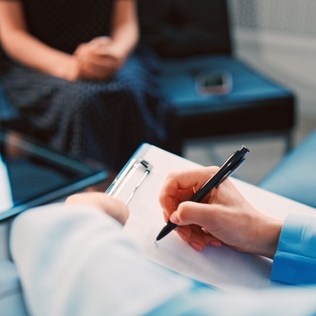cognitive behavioral therapy session in Scottsdale AZ with therapist writing notes and guiding client through thought patterns at Pathways Counseling Services