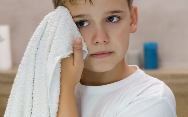 Child and Teen bipolar disorder therapy Scottsdale, AZReflection of schoolboy wiping his face with a towel after washing in bathroom. Child and Teen bipolar disorder therapy Scottsdale, AZ