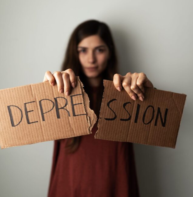 Person experiencing depression holding sign representing emotional struggle and seeking therapy support in Scottsdale AZ