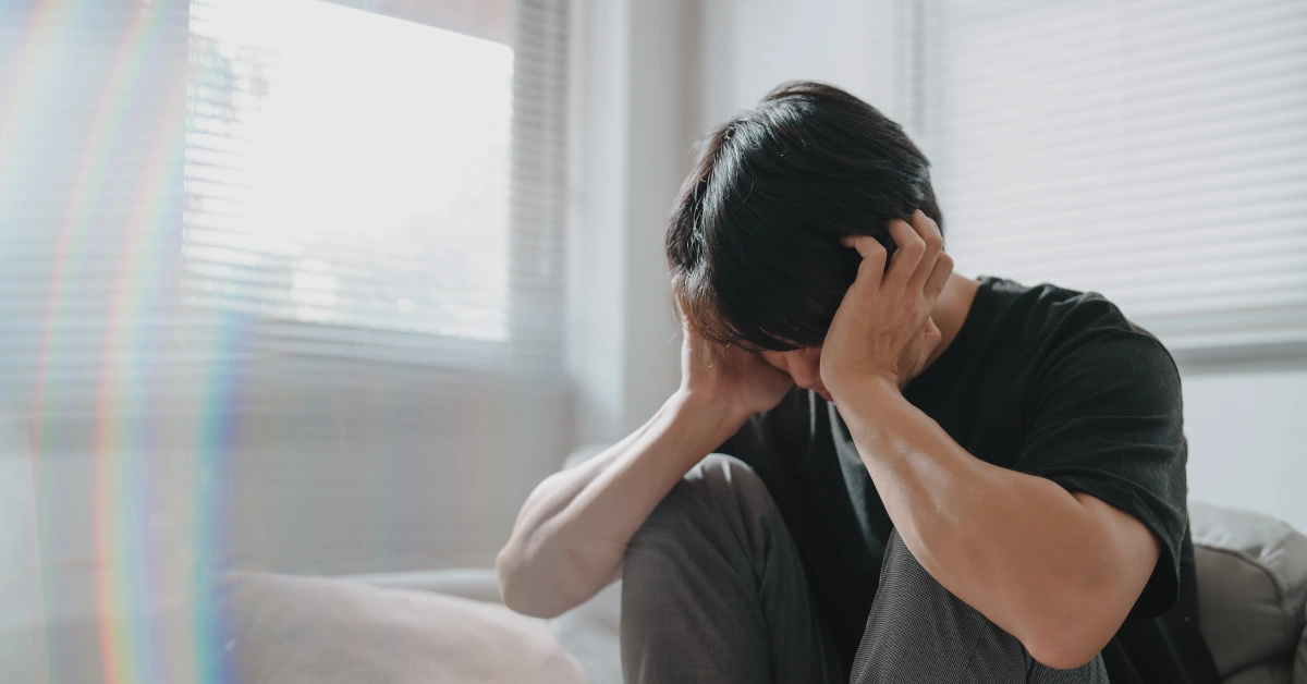 Person sitting alone with their head in their hands, representing anxiety, emotional distress, and feelings of overwhelm.