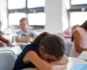 Child experiencing school anxiety in a classroom, representing emotional distress and school refusal in children.