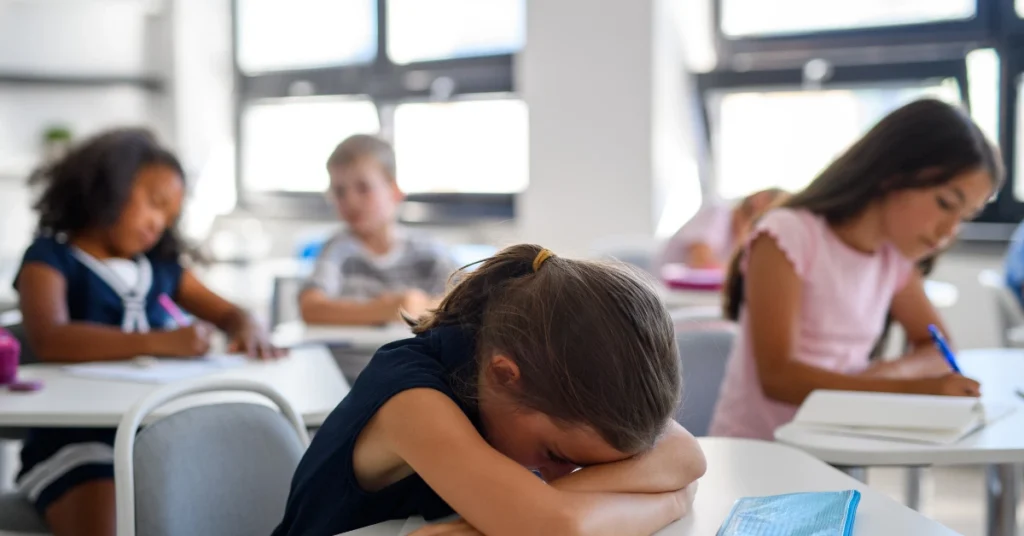 Child experiencing school anxiety in a classroom, representing emotional distress and school refusal in children.