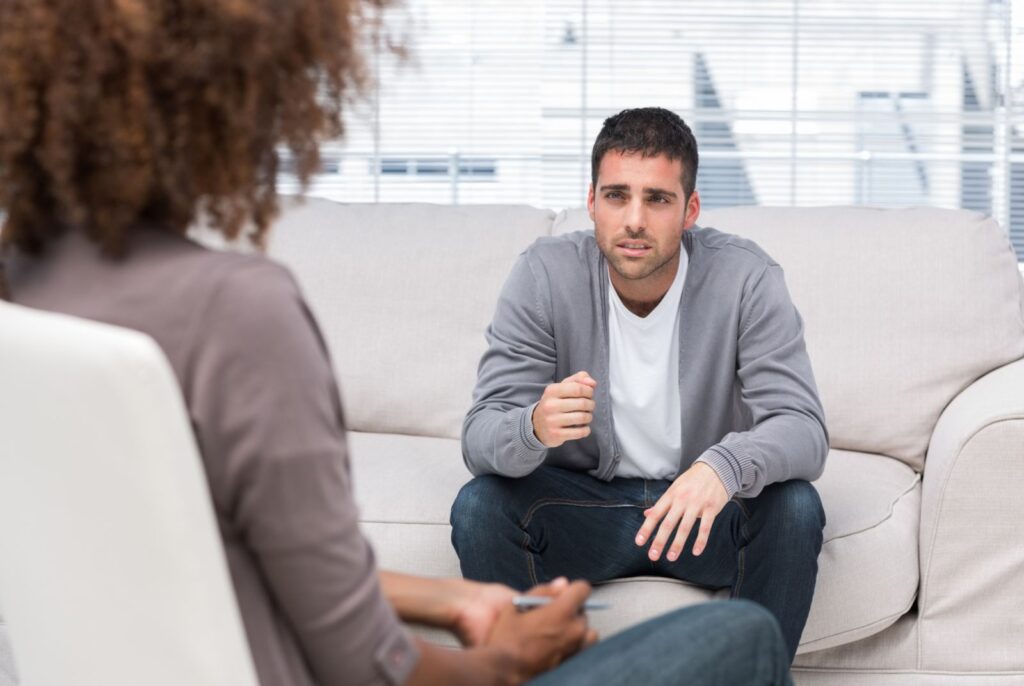 Cognitive Behavioral Therapy - Man Sitting Across from a Woman On Couch Wearing Grey Sweater and Jeans